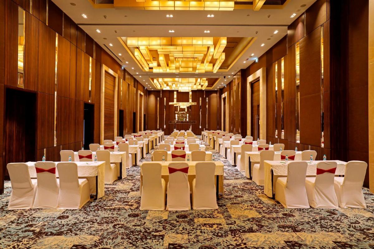 a row of tables and chairs in a banquet hall at Holiday Inn Chennai OMR IT Expressway by IHG in Chennai