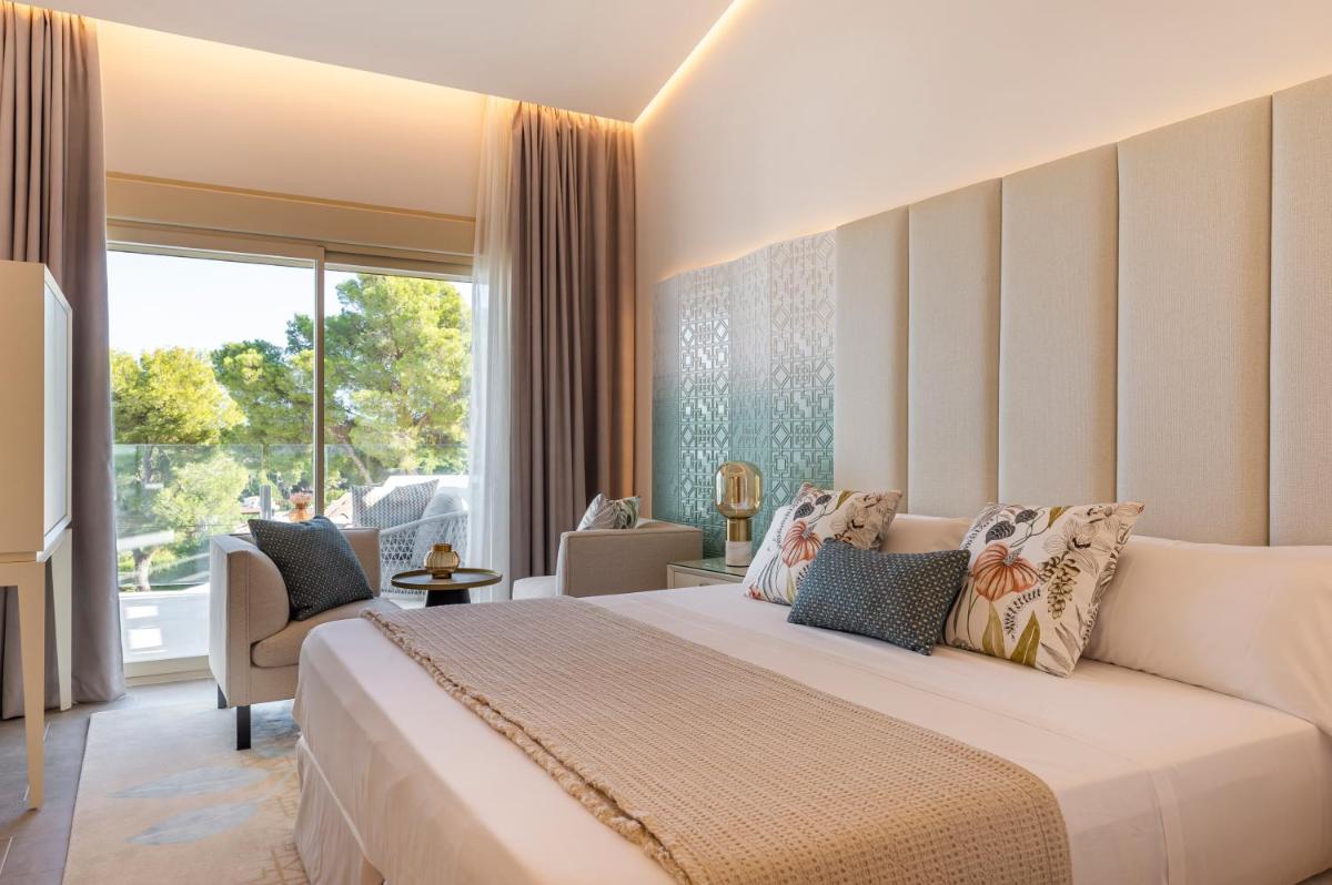 Un dormitorio con una cama grande y una ventana grande. en Dionis Boutique Hotel & Spa, en Jávea