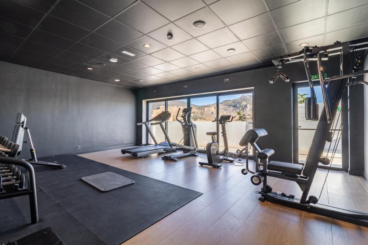 un gimnasio con varias cintas de correr y máquinas elípticas en Hotel El Mirador, en Loja