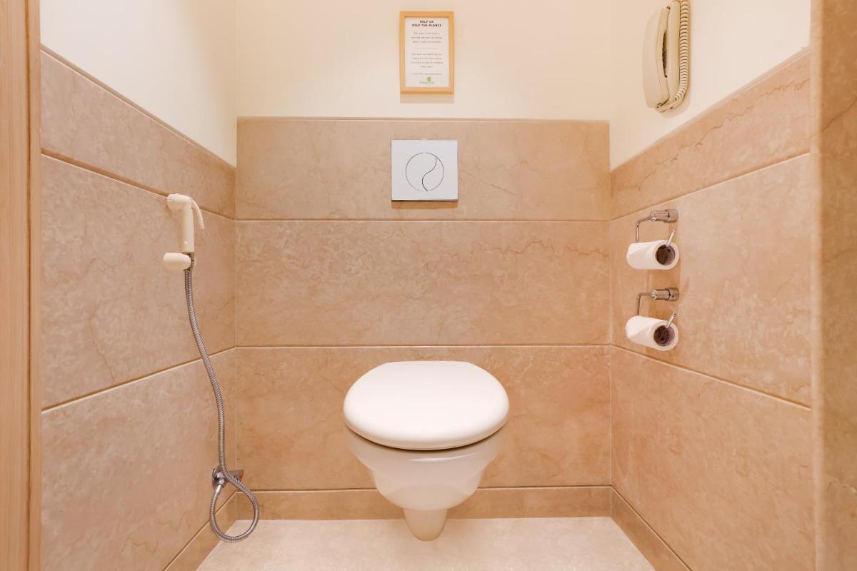 a bathroom with a toilet and a shower at Lemon Tree Premier, Delhi Airport in New Delhi a bathroom with a toilet and a shower at Lemon Tree Premier, Delhi Airport in New Delhi