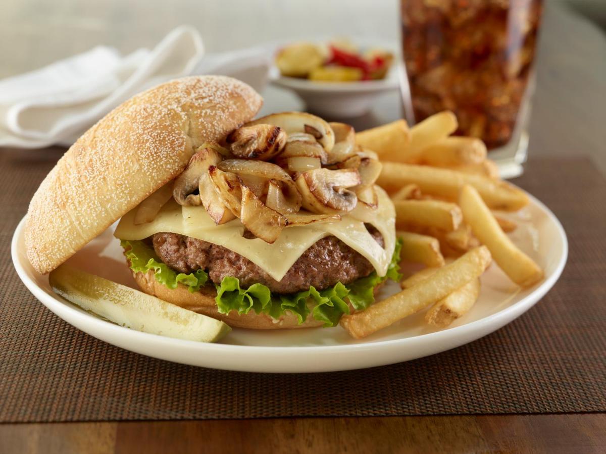 a plate with a hamburger and french fries on a table at Hilton Garden Inn, Trivandrum in Trivandrum