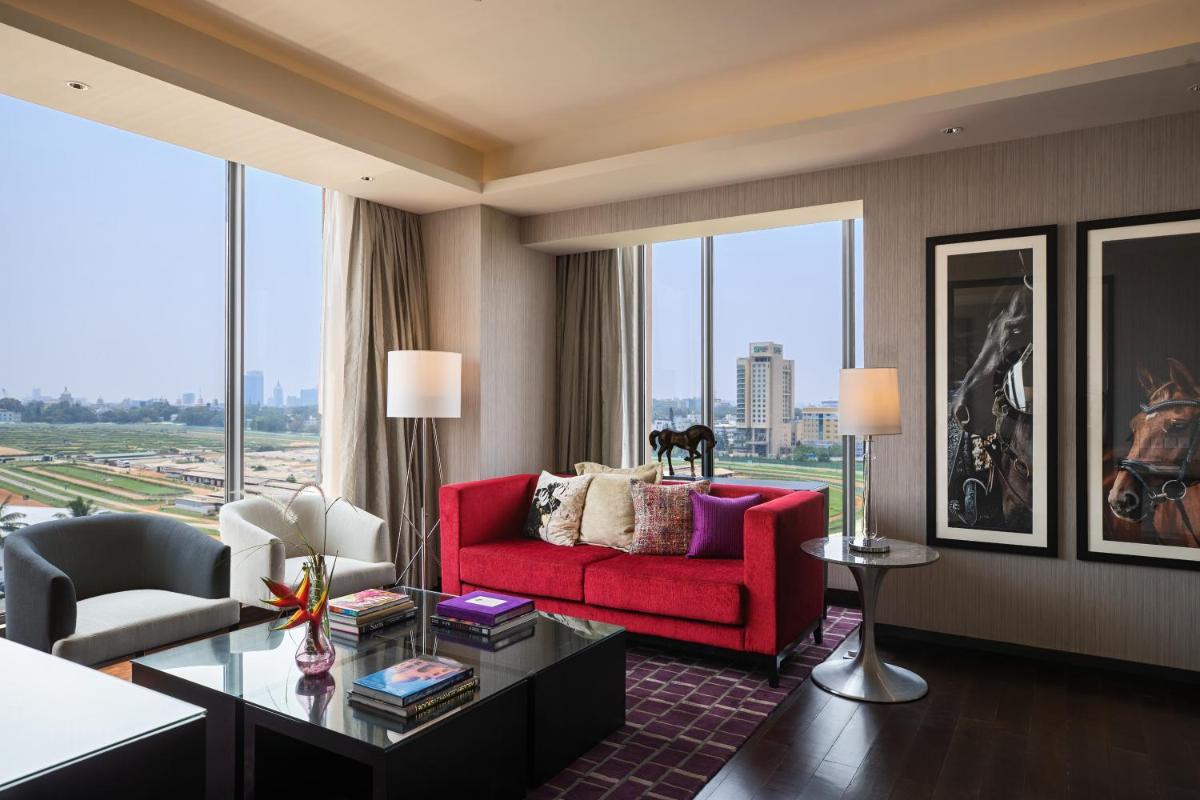 a living room with a red couch and a table at Renaissance Bengaluru Race Course Hotel in Bengaluru
