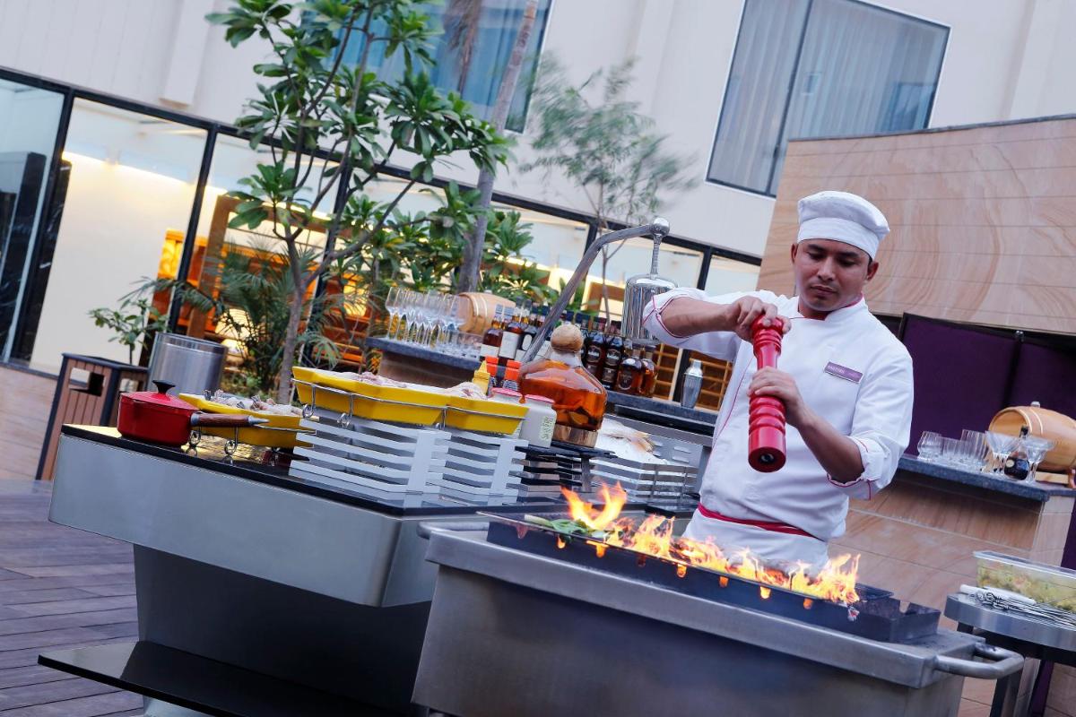 a chef is preparing food on a grill at InterContinental Jaipur Tonk Road by IHG in Jaipur