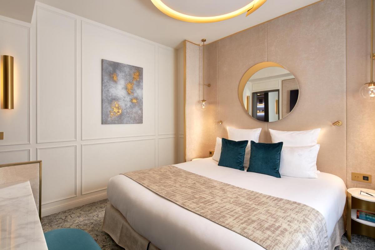 une chambre d'hôtel avec un lit et un miroir dans l'établissement Maison Albar - Le Vendome, à Paris 37 autres photos