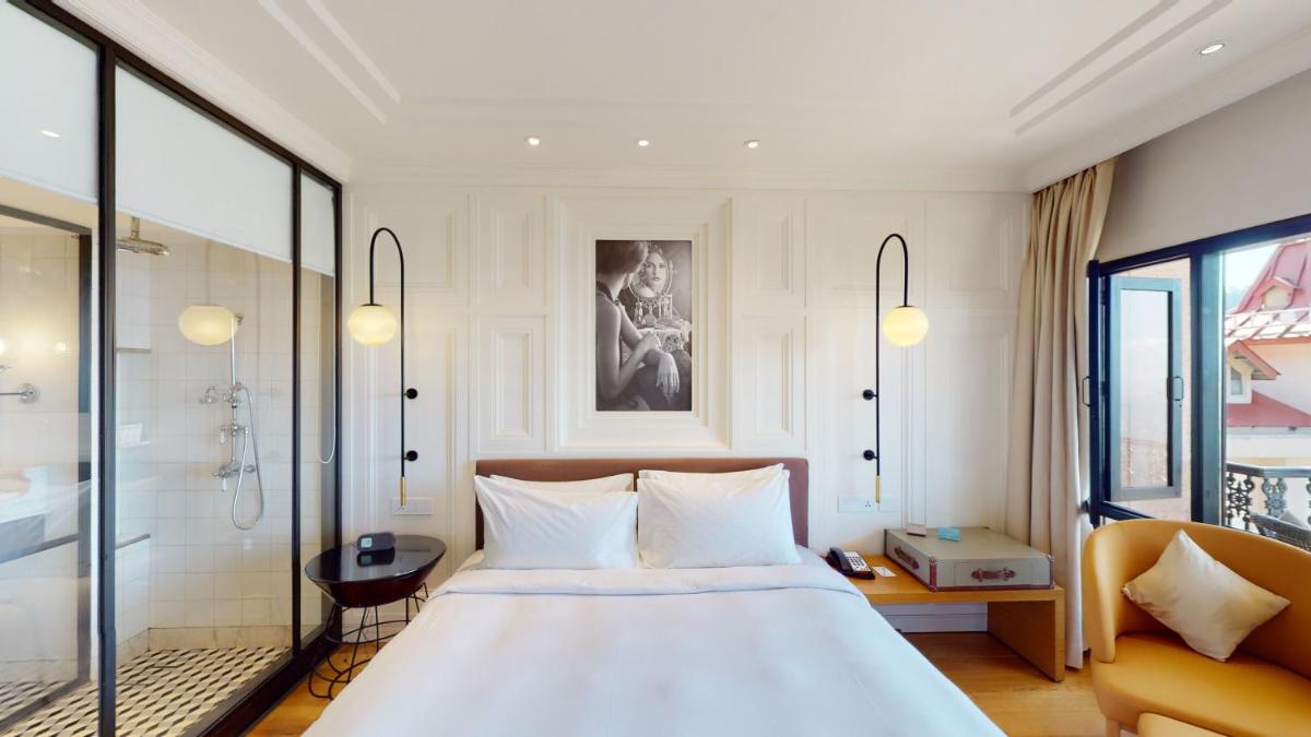 a bedroom with a large white bed and a shower at Radisson Hotel Shimla in Shimla