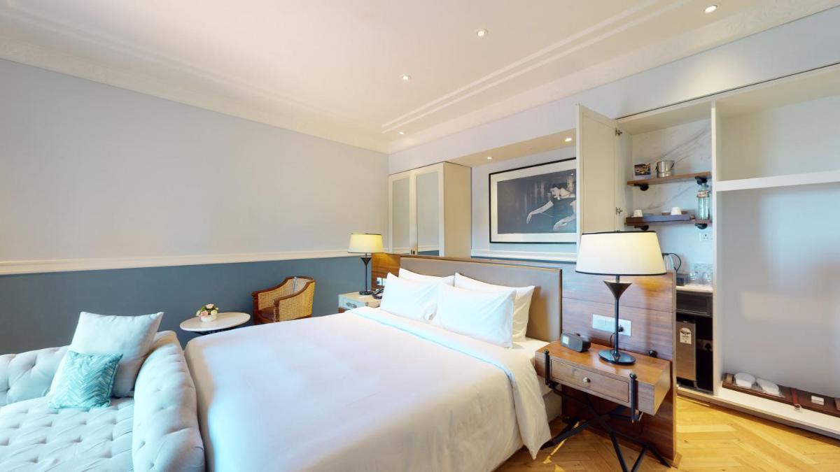 a bedroom with a large white bed and a couch at Radisson Hotel Shimla in Shimla