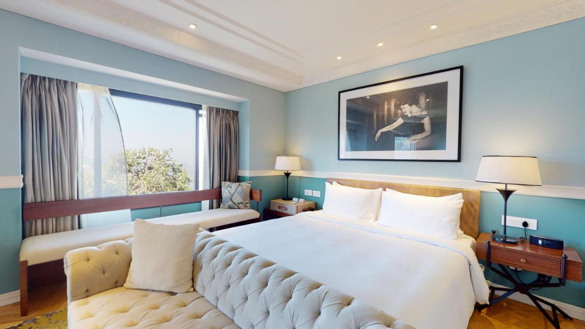 a hotel room with a large bed and a couch at Radisson Hotel Shimla in Shimla