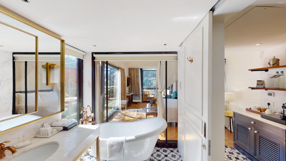 a bathroom with a tub and a large mirror at Radisson Hotel Shimla in Shimla