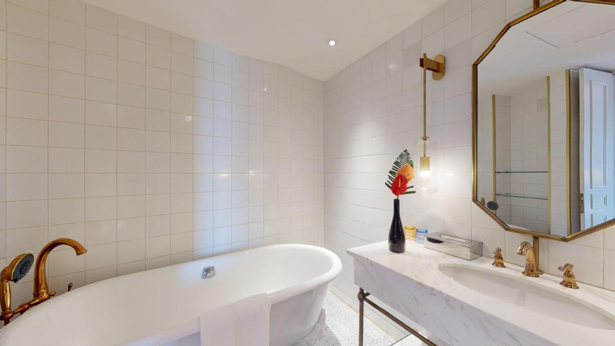 a white bathroom with a tub and a sink at Radisson Hotel Shimla in Shimla