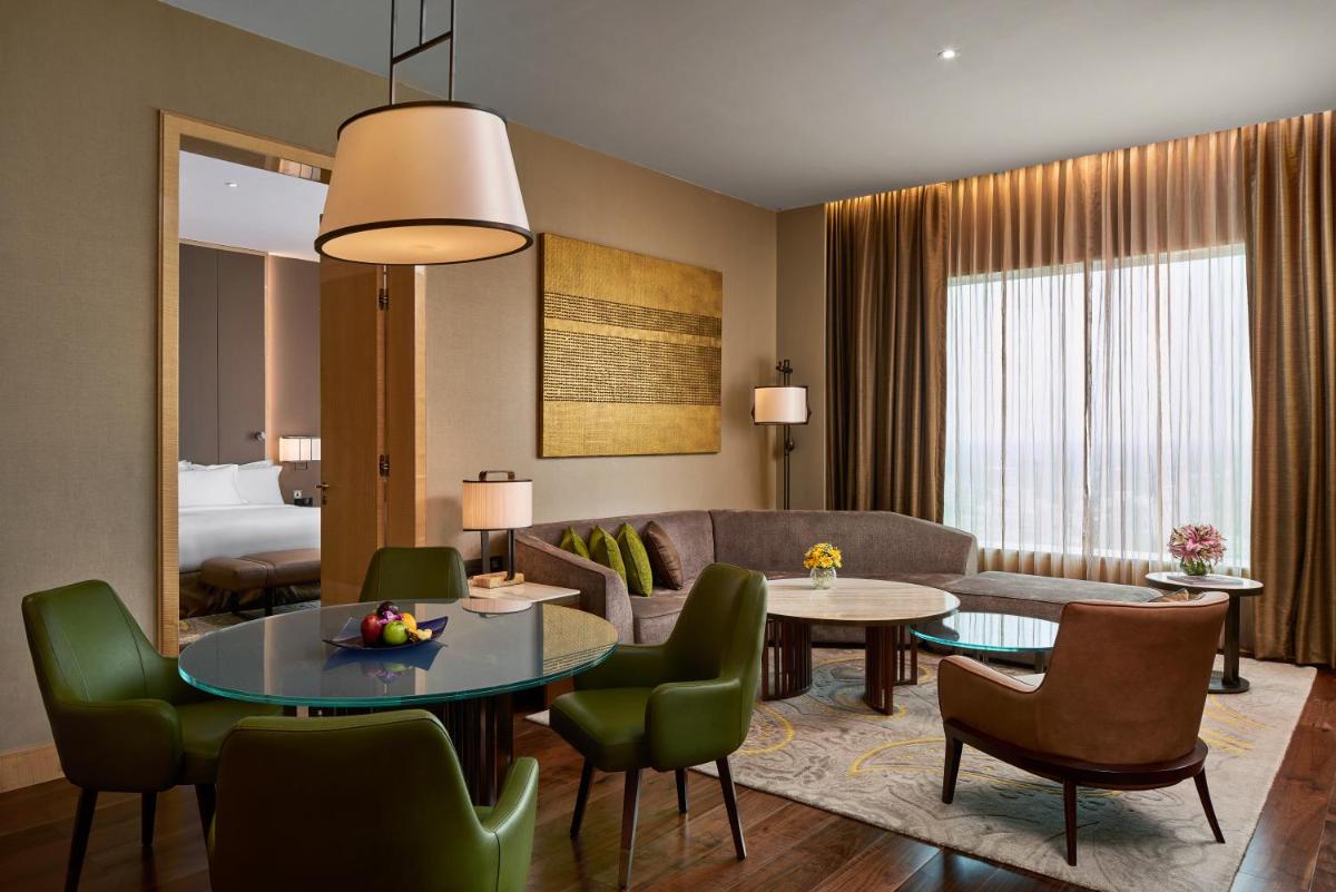 a living room with a couch and a table at Conrad Pune in Pune