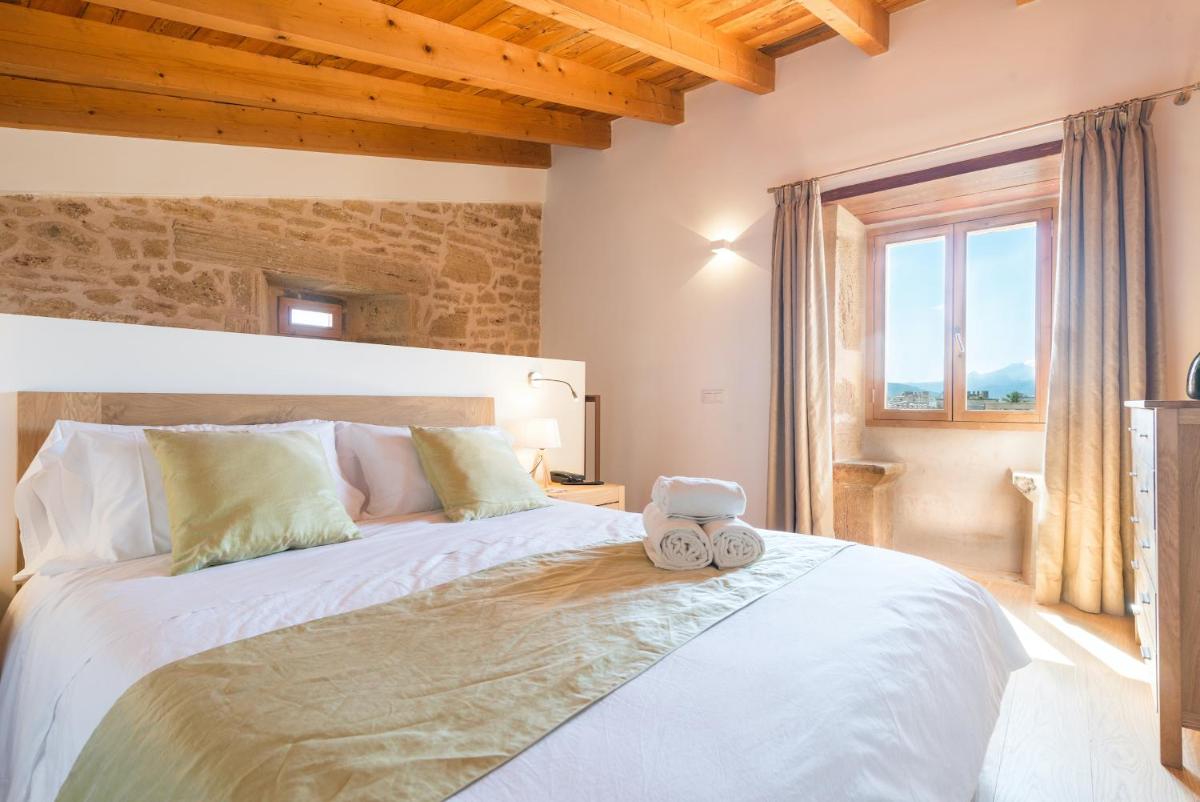 Un dormitorio con una gran cama blanca en una habitación. en Bordoy Mostatxins - Hotel Boutique Adults Only, en Alcudia