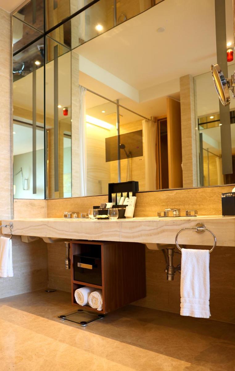 a bathroom with a large sink and a large mirror at Conrad Pune in Pune