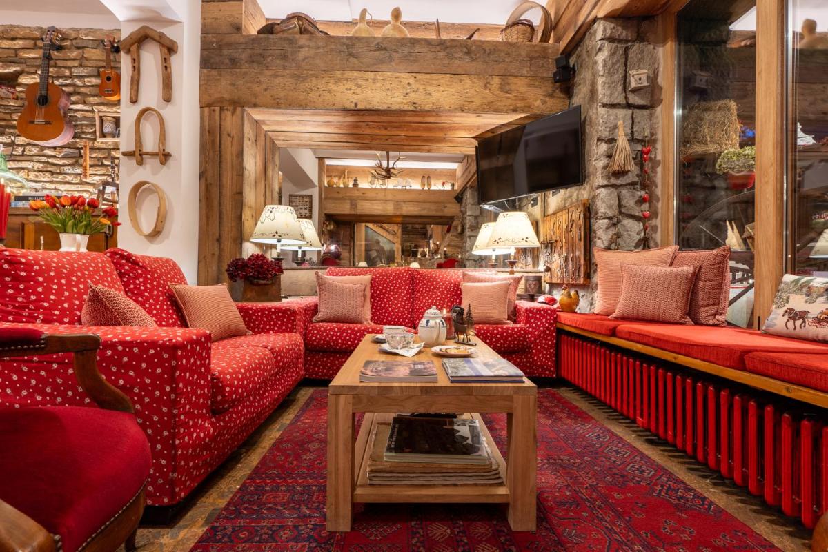 Una sala de estar con sofás rojos y una mesa. en Hotel Aran La Abuela, en Vielha