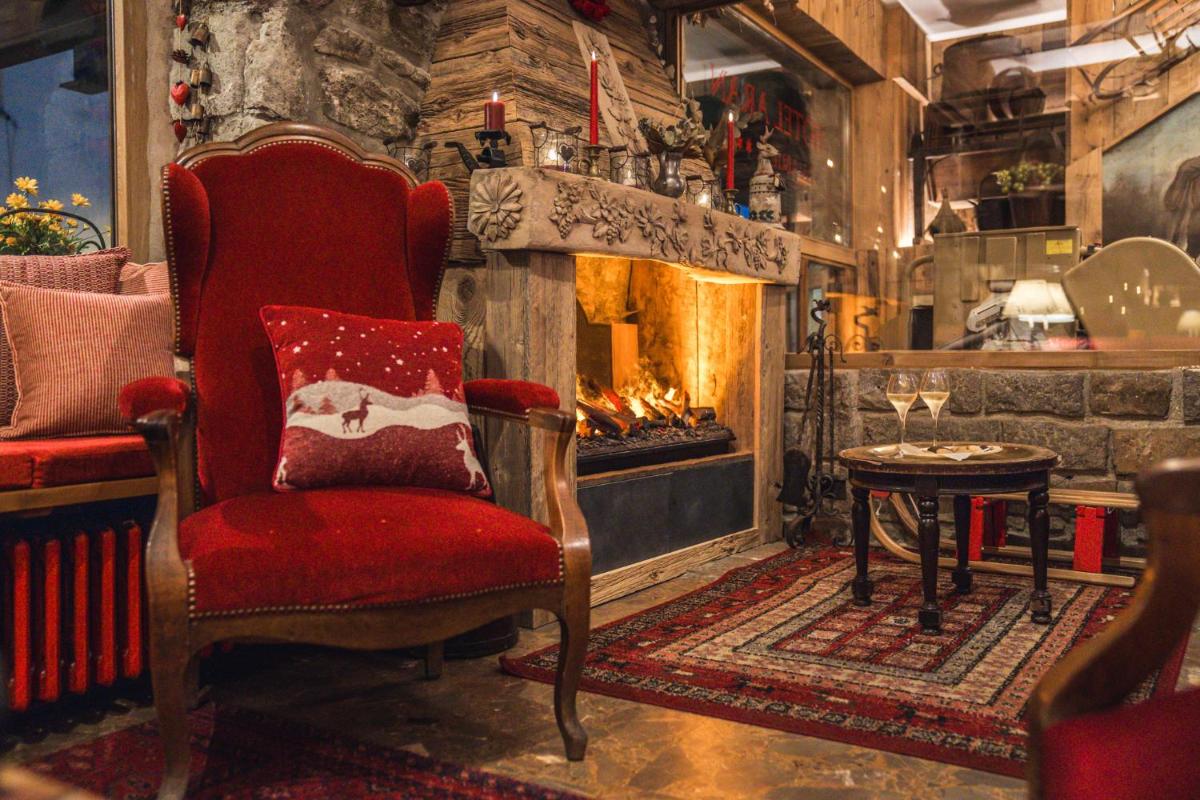 Una sala de estar con una silla y una chimenea. en Hotel Aran La Abuela, en Vielha