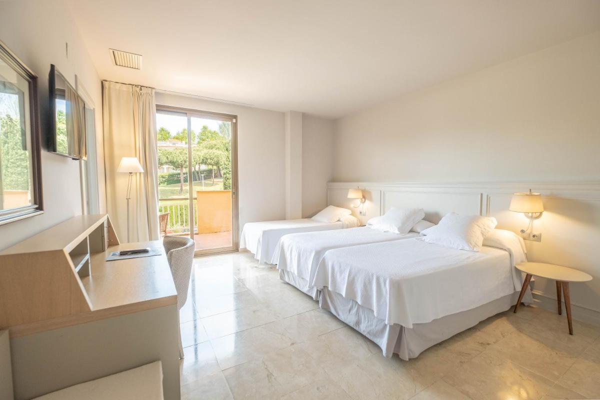 Una habitación de hotel con dos camas y una ventana. en S'Agaró Hotel Spa & Wellness, en S'Agaró 34 fotos más