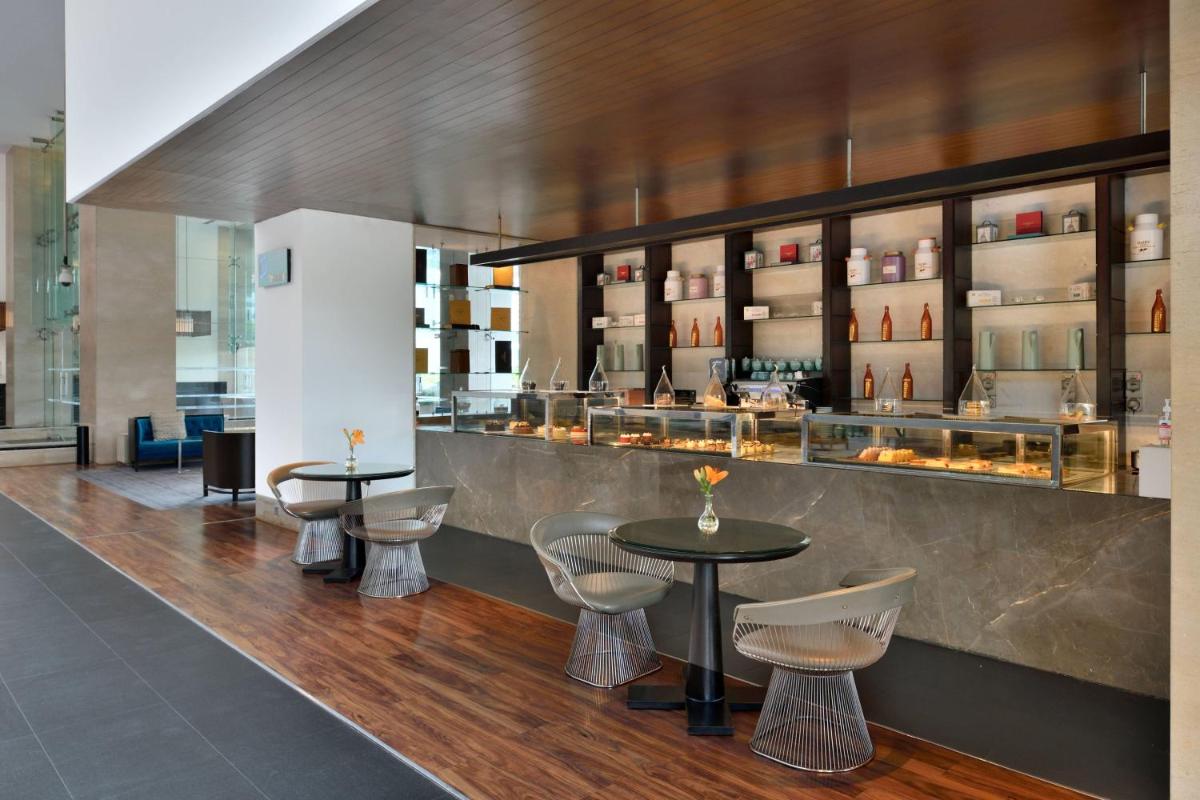 a restaurant with two tables and chairs and a counter at The Westin Hyderabad Mindspace in Hyderabad