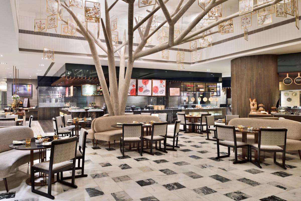 a restaurant with tables and chairs and a tree at The St. Regis Mumbai in Mumbai