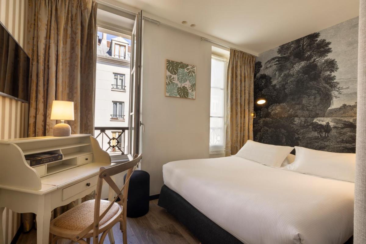 une chambre d'hôtel avec un lit, un bureau et une fenêtre dans l'établissement Hotel L’Antoine, à Paris