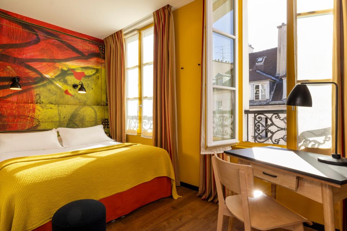 une chambre avec un lit, un bureau et des fenêtres dans l'établissement Hotel L’Antoine, à Paris