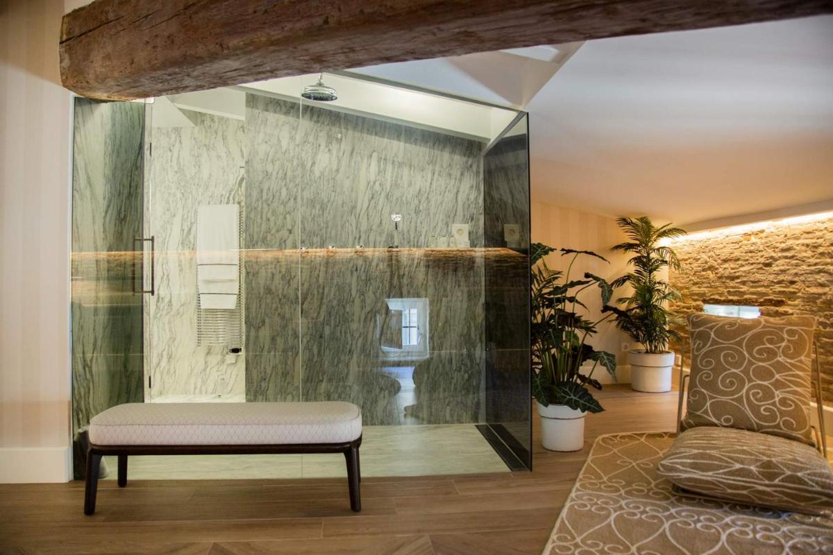 baño con banco y ducha acristalada en MYR Palacio Vallier, en Valencia