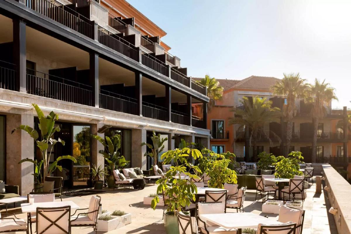 um pátio externo de um hotel com mesas e cadeiras em Grande Real Villa Itália Hotel & Spa - A Leading Hotel of the World em Cascais