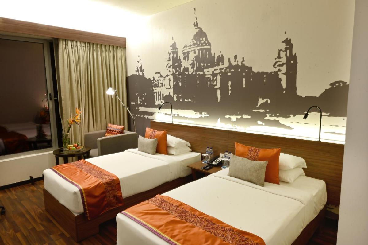 a hotel room with two beds and a mural at Vivanta Kolkata EM Bypass in Kolkata