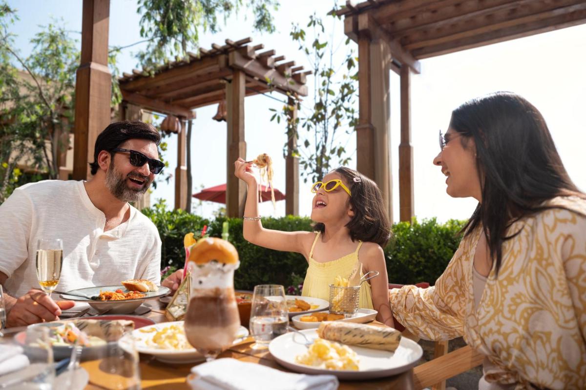 a group of people sitting at a table eating food at The Westin Resort & Spa Himalayas in Rishīkesh