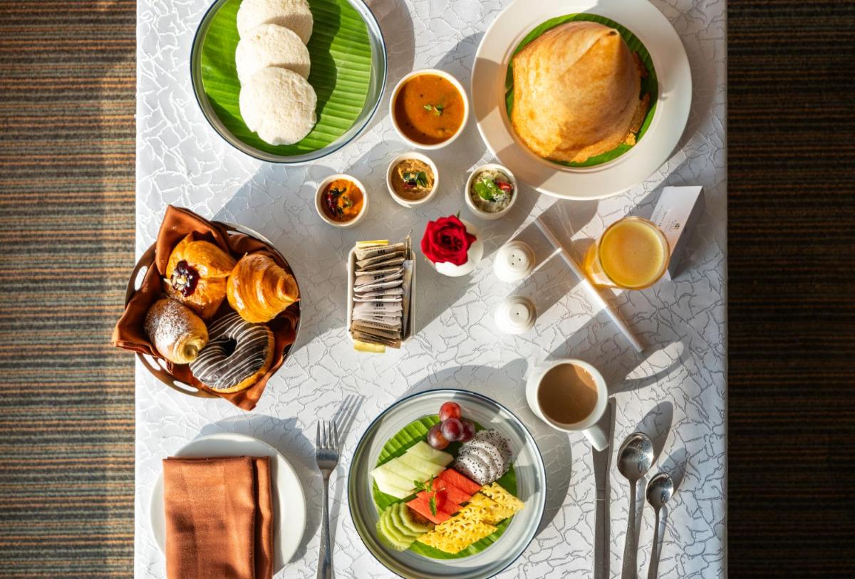 a table with plates of food on top at Hyatt Place Gurgaon Udyog Vihar in Gurgaon