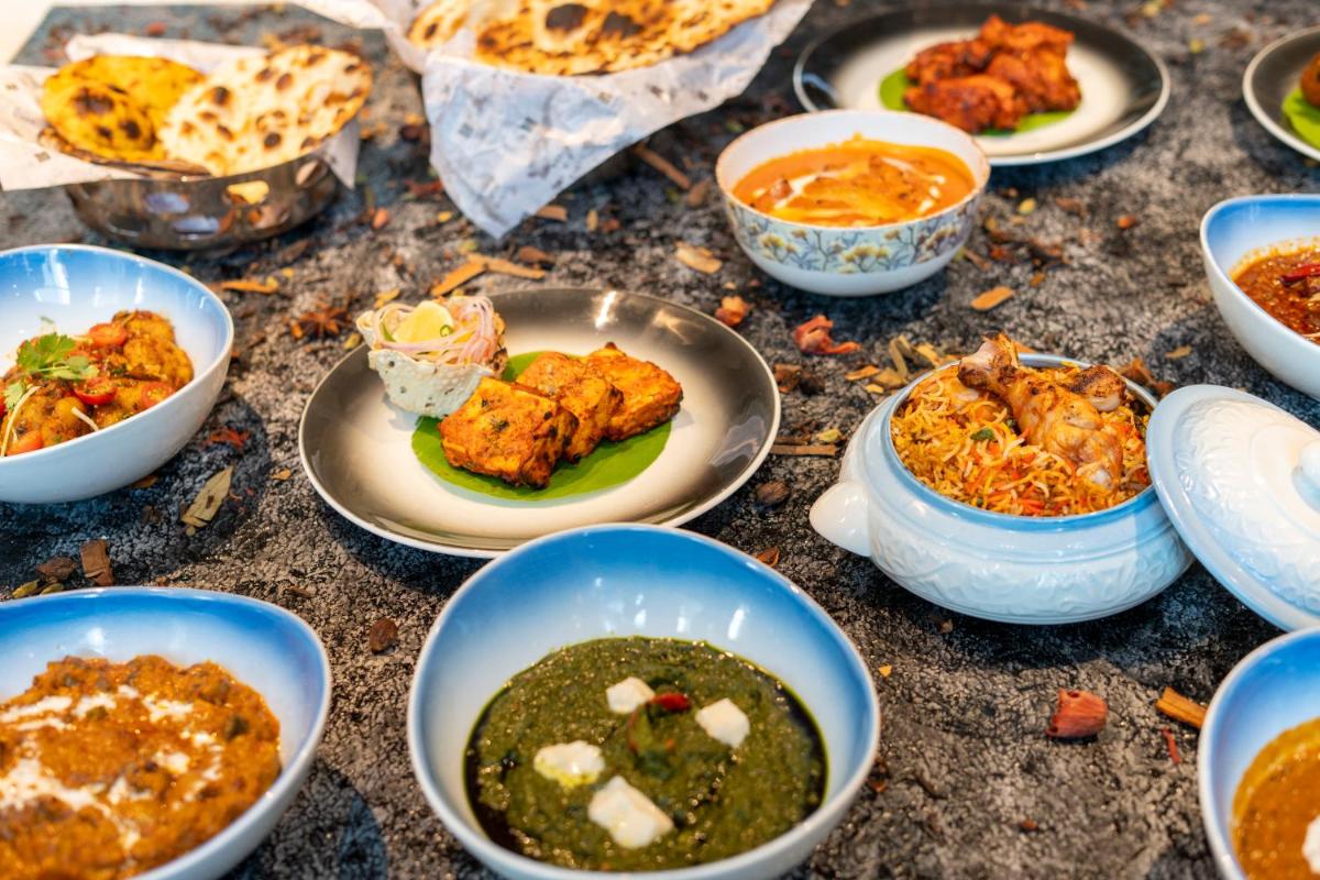 a table topped with bowls of food on plates at Hyatt Place Gurgaon Udyog Vihar in Gurgaon