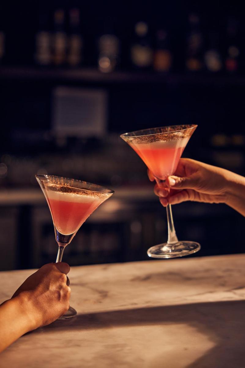 two people holding martini glasses on a table at Hyatt Place Gurgaon Udyog Vihar in Gurgaon