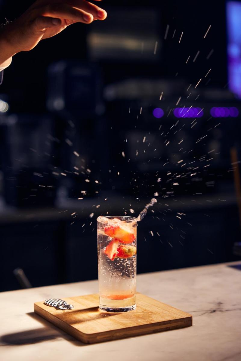 a person is sprinkling a drink on a table at Hyatt Place Gurgaon Udyog Vihar in Gurgaon