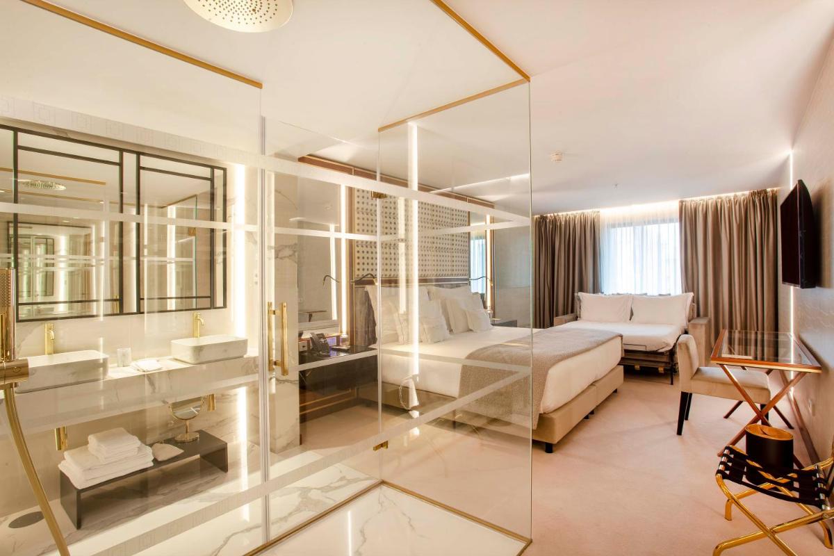 um quarto com uma cama, uma pia e um espelho em Wine & Books Porto Hotel - Small Luxury Hotels Of The World no Porto