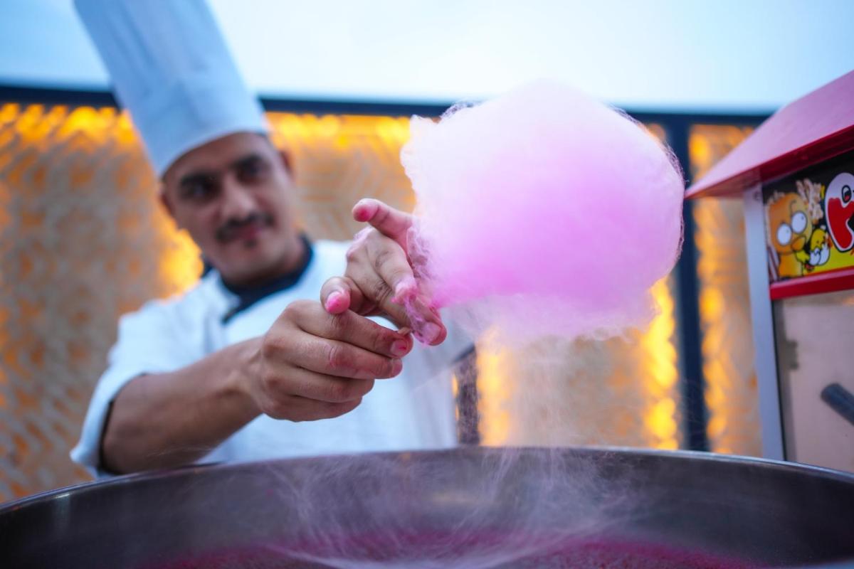 a chef is cooking food in a pot at DoubleTree By Hilton Jaipur Amer in Jaipur