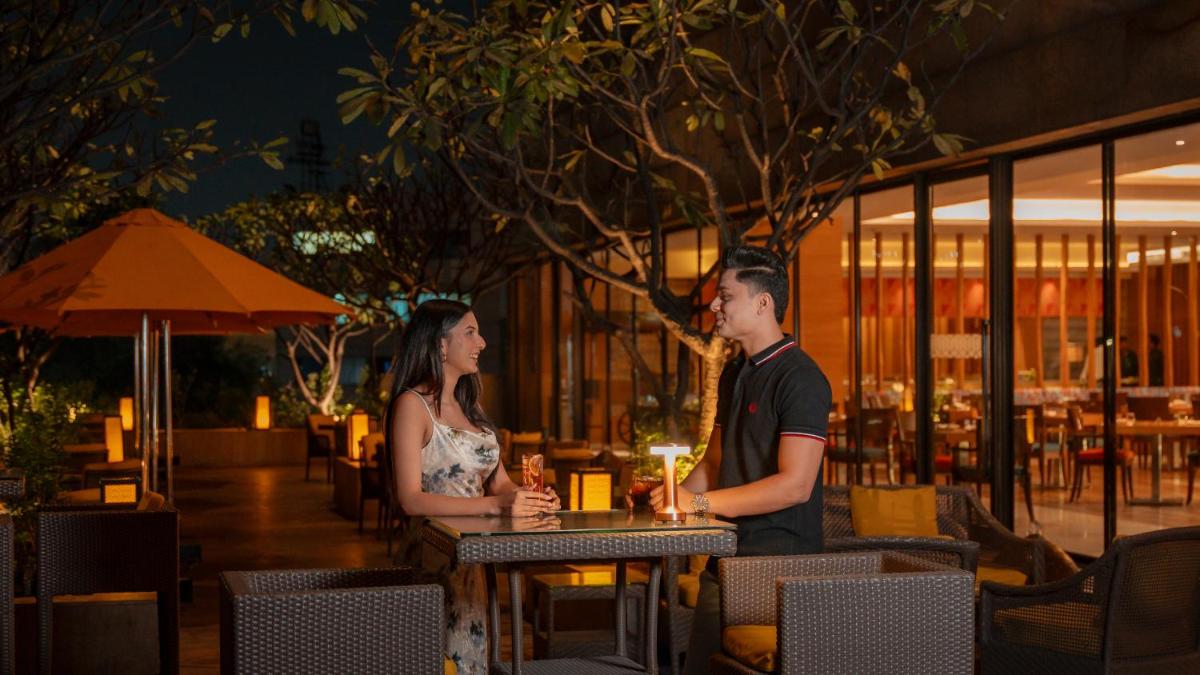 a man and a woman standing at a table in a restaurant at Hyatt Pune in Pune