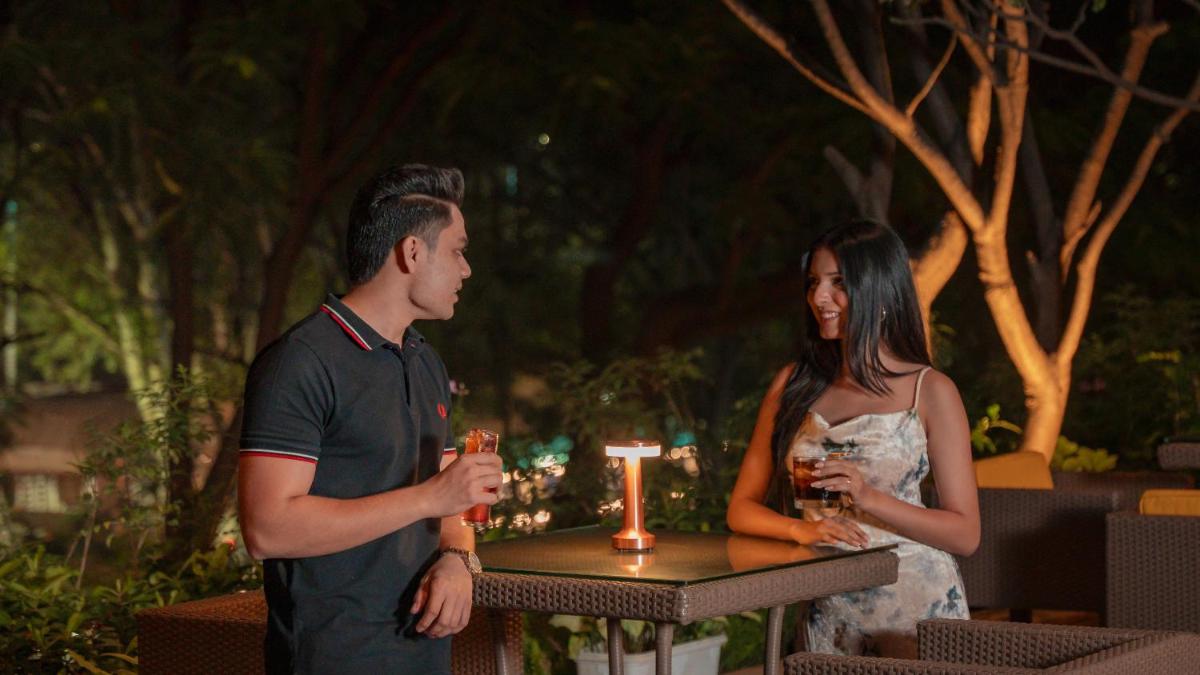 a man and a woman standing next to a table with a candle at Hyatt Pune in Pune