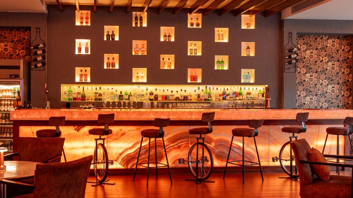 a bar with bar stools in a restaurant at Hyatt Pune in Pune