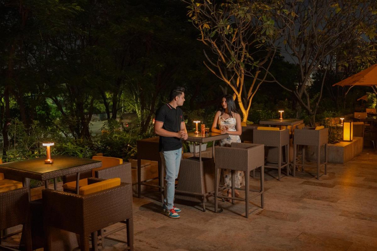 a man and a woman standing in front of tables and chairs at Hyatt Pune in Pune
