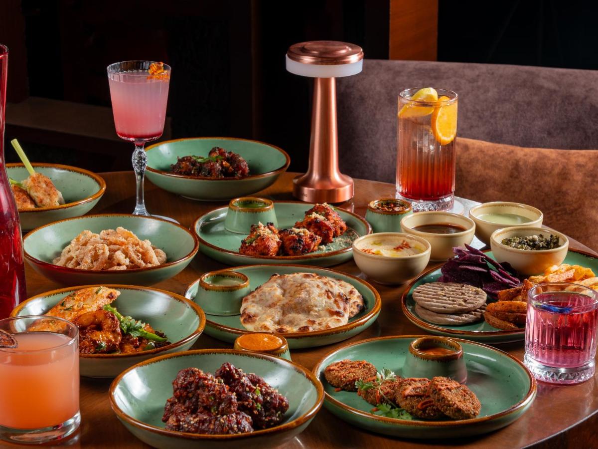 a table topped with plates of food and drinks at Hyatt Pune in Pune