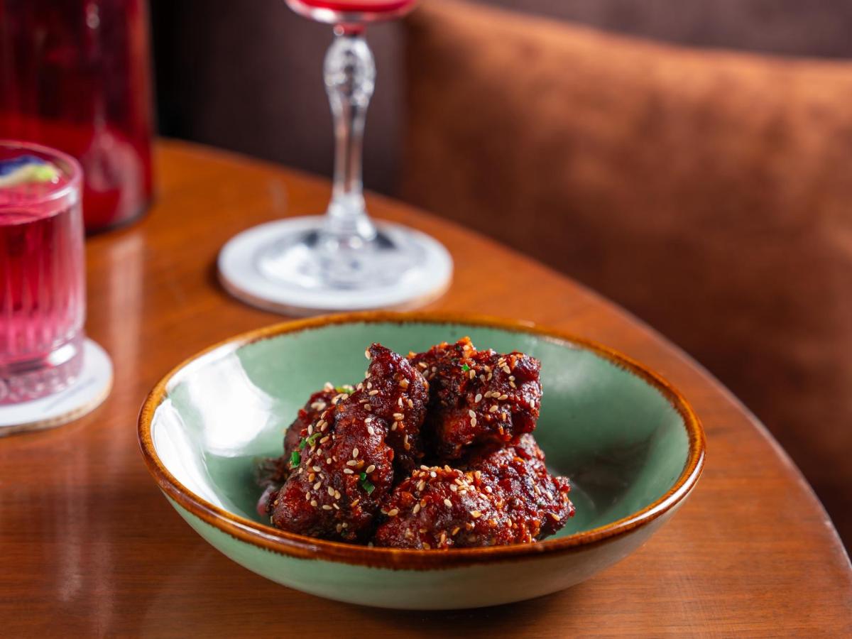 a bowl of food on a table with a glass of wine at Hyatt Pune in Pune