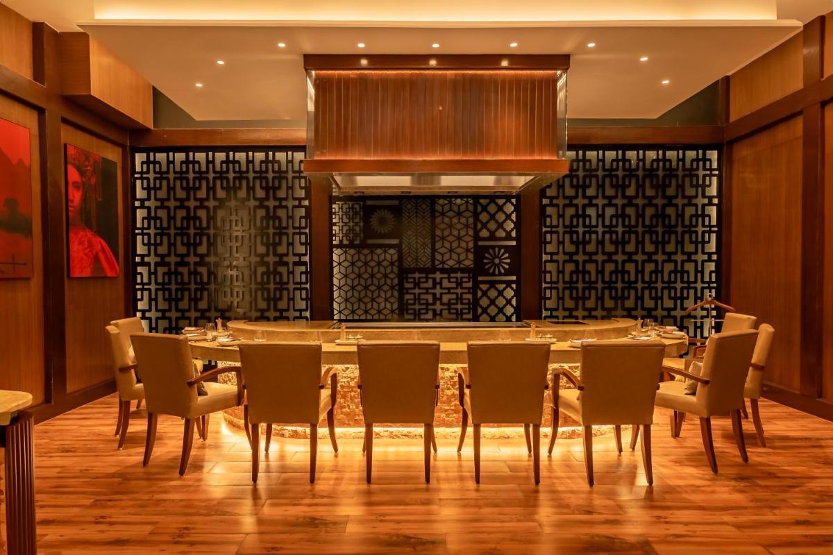 a dining room with a table and chairs at Hyatt Pune in Pune