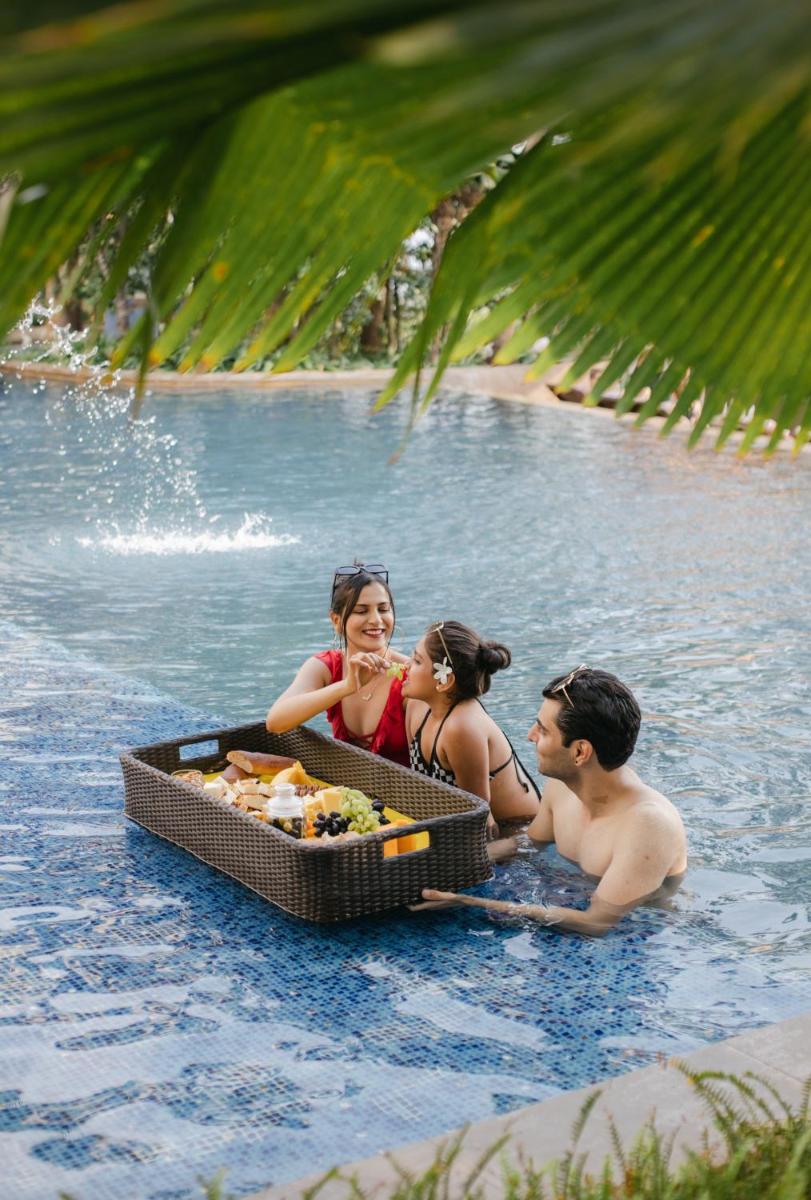 a group of people in the water with a tray of food at Hyatt Pune in Pune