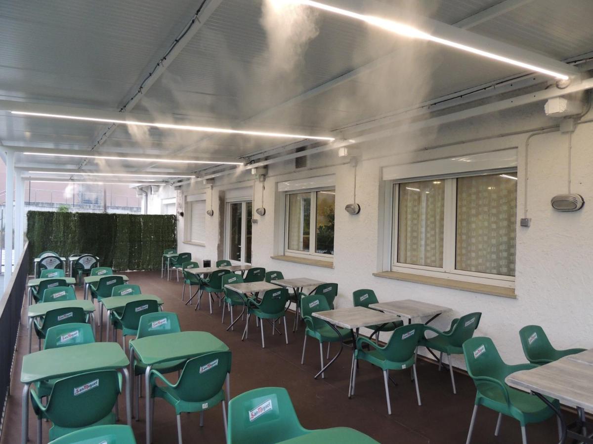 un aula vacía con mesas y sillas verdes en Hotel Vilobi, en Vilobí d'Onyar 28 fotos más