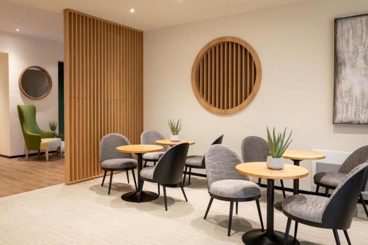 une salle d'attente avec des tables et des chaises dans l'établissement Best Western Auray le Loch, à Auray