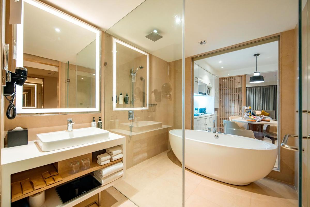 a bathroom with a large tub and a sink at Novotel Ahmedabad in Ahmedabad