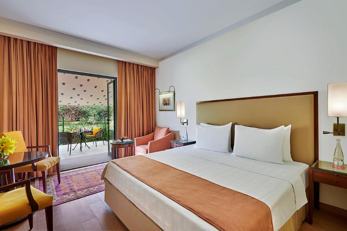 a hotel room with a bed and a balcony at Trident Agra in Agra
