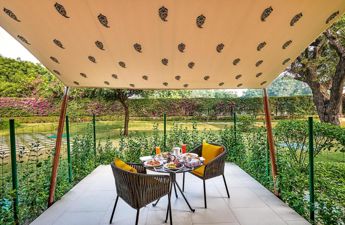 a table and chairs under a large umbrella at Trident Agra in Agra