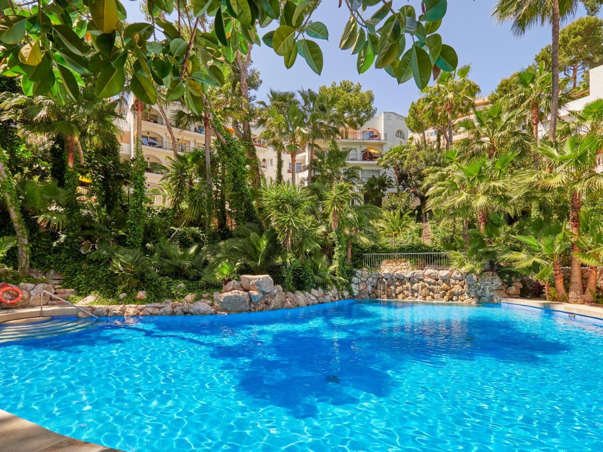 una gran piscina azul con árboles y edificios en Hotel Bon Sol Resort & Spa, en Illetas