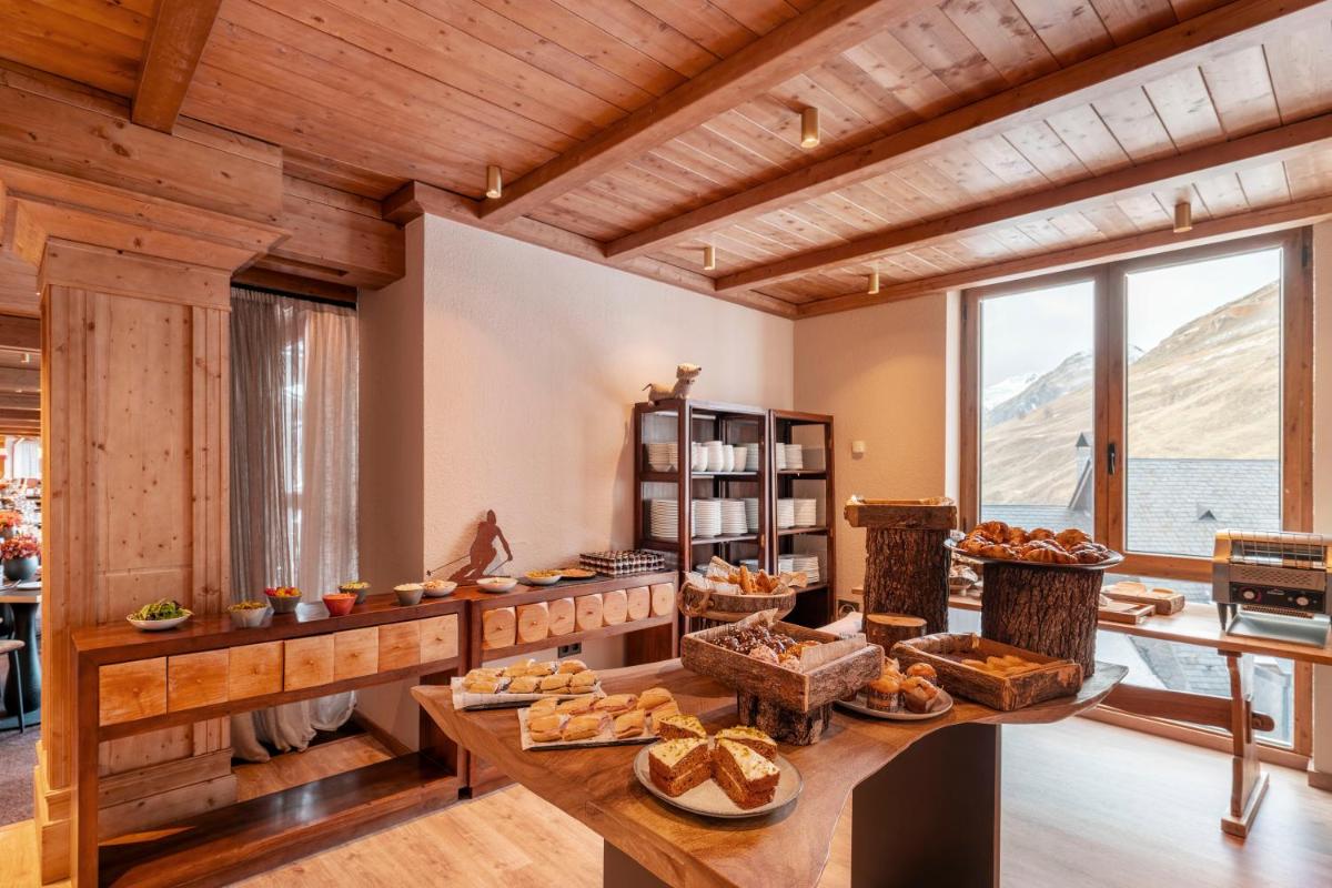 Habitación grande con una mesa con pan. en Eurostars La Pleta, en Baqueira Beret