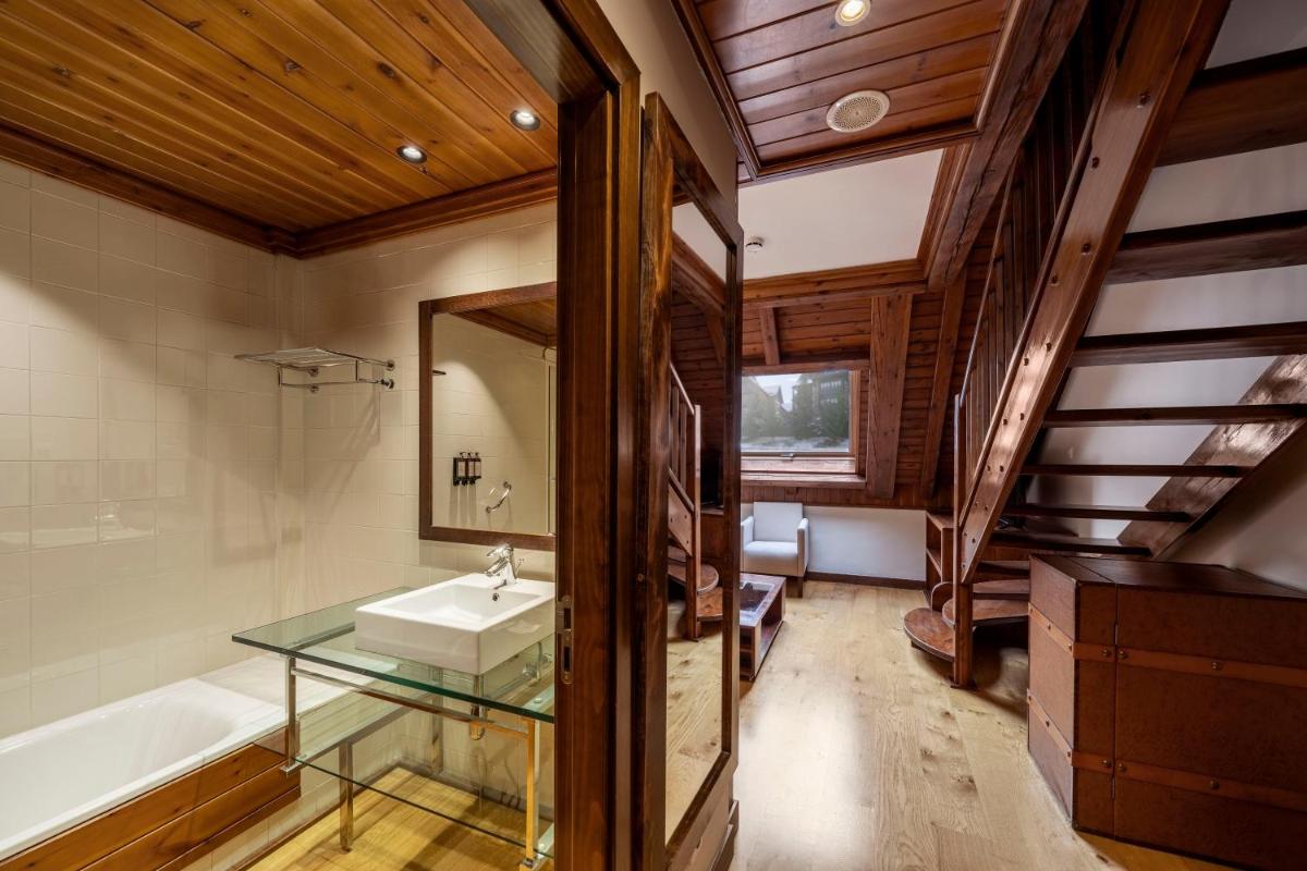 y baño con lavabo de cristal y bañera. en Eurostars La Pleta, en Baqueira Beret