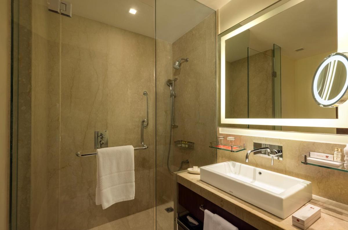 a bathroom with a sink and a shower with a mirror at Trident Agra in Agra